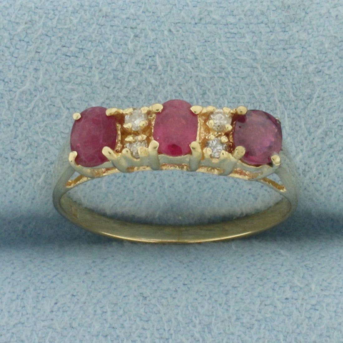 Ruby and Diamond Ring in 14K Yellow Gold: In 14k yellow gold. Contains 3 high quality natural 4x3mm Ruby gemstones with intense color. Accented with 4 high quality .01ct diamonds. Size 6.5. 1.9g.