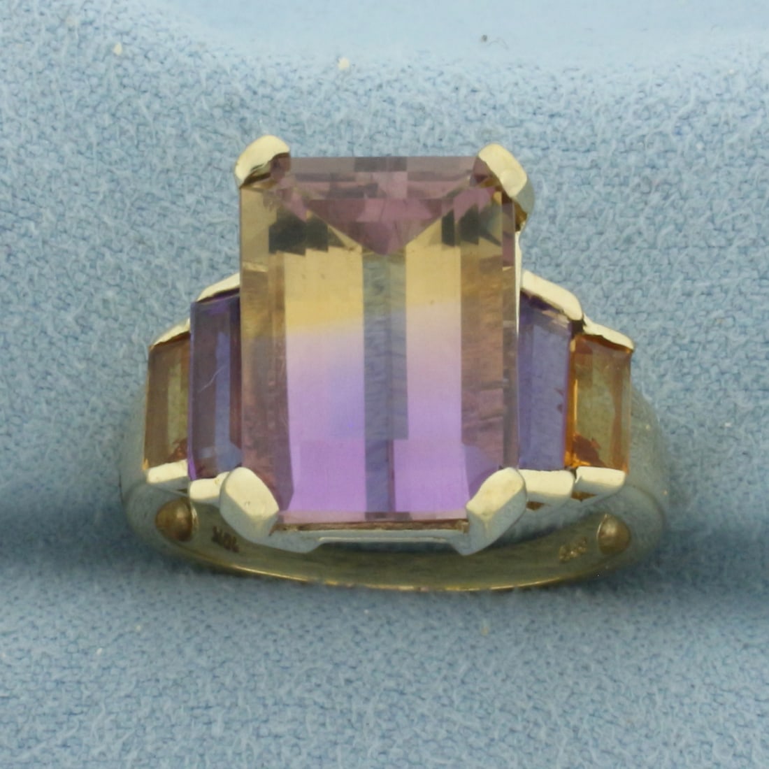 Ametrine, Amethyst, and Citrine Ring in 10K Yellow Gold: In 10k yellow gold. Contains 1 emerald cut high quality natural Ametrine gemstone, 14x10mm. Also contains 2 emerald cut Amethyst, 7x3.5mm each, and 2 emerald cut Citrine, 5x3mm each. All gems have