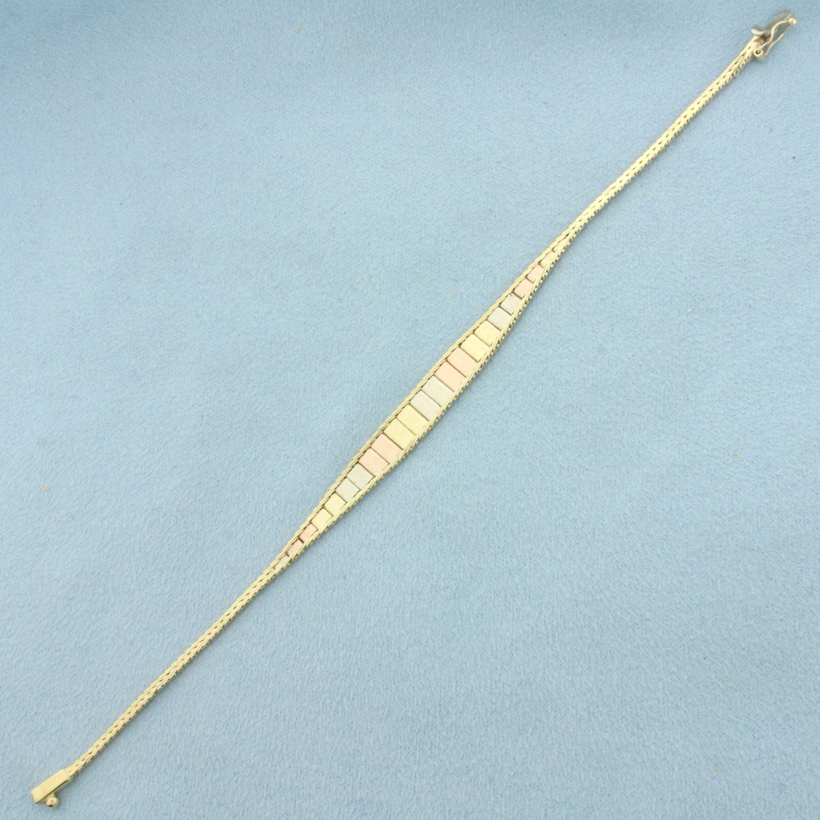 Tri-Color Gold Bracelet in 14k Yellow, White, and Rose Gold: In 14k Yellow, White, and Rose Gold. 7 inches long. 6.7mm wide at widest point. Italian made. Slide clasp with safety latch. 5.6g.