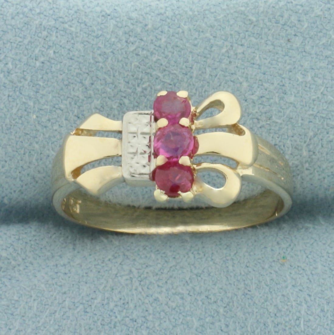 Ruby Ring in 14K Yellow Gold: In 14k yellow gold. 10mm wide at widest spread on top of ring. Contains three high quality natural Ruby gemstones, 3mm each, with bright color and excellent clarity. Size 8.5. 3.0g.