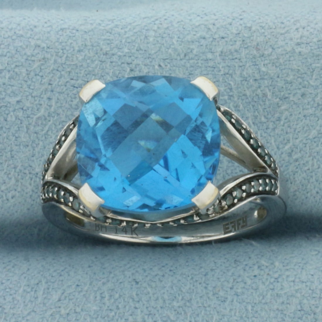 Vintage Effy Blue Topaz and Blue Diamond Ring in 14K White Gold: Designer signed Effy. In 14k white gold. Contains 1 checkerboard cushion cut 12mm Swiss Blue Topaz gemstone with electric blue color and excellent clarity. Accented with 58 high quality blue 1/2pt dia