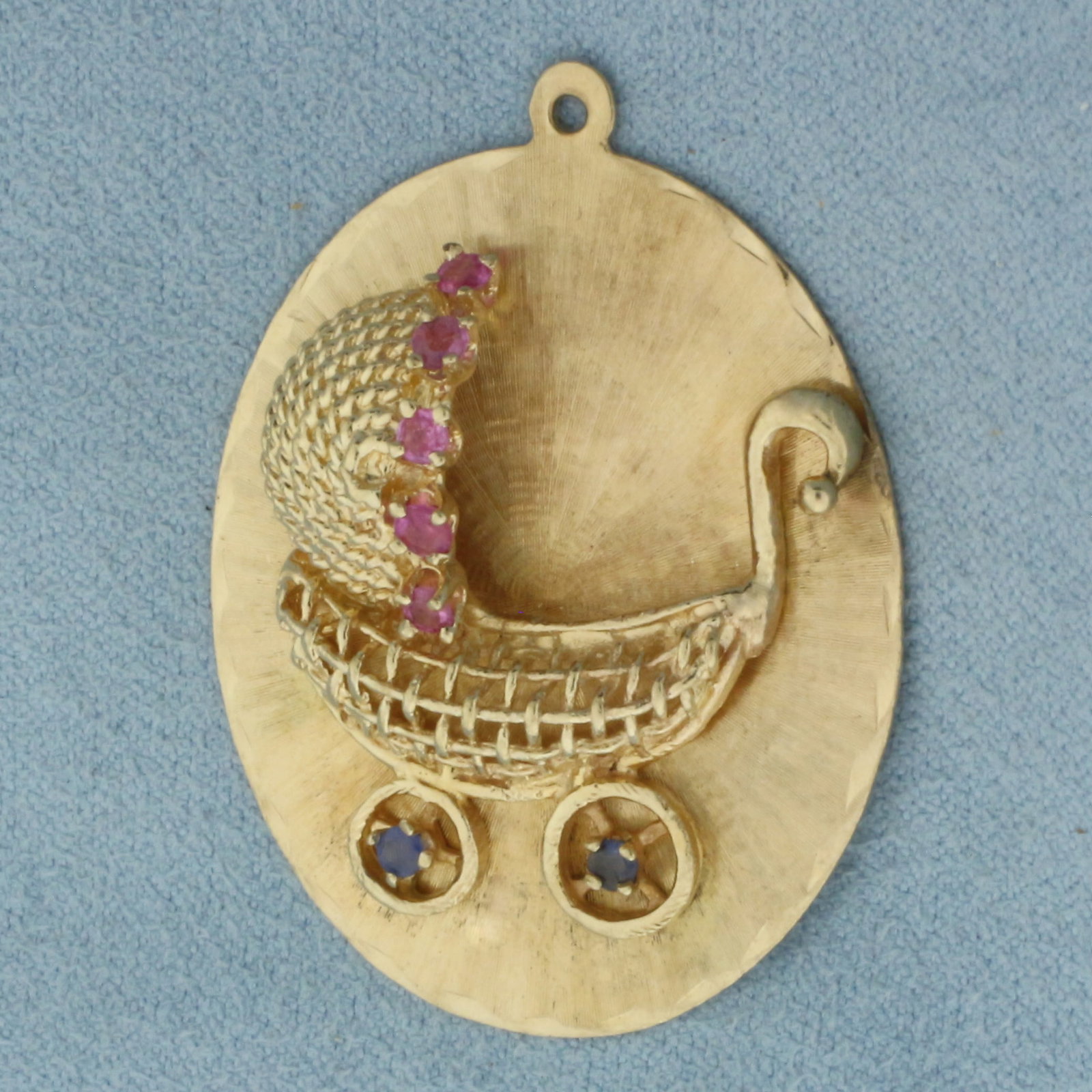 Vintage Large Engravable Baby Buggy Stroller Pendant or Charm in 14K Yellow Gold: In 14k yellow gold. Measures 1 5/8 inches long by 1 1/4 inches wide. Contains two Sapphire and five Ruby high quality natural 2mm gemstones with bright color. Blank bank to engrave name or date. 9.3g.