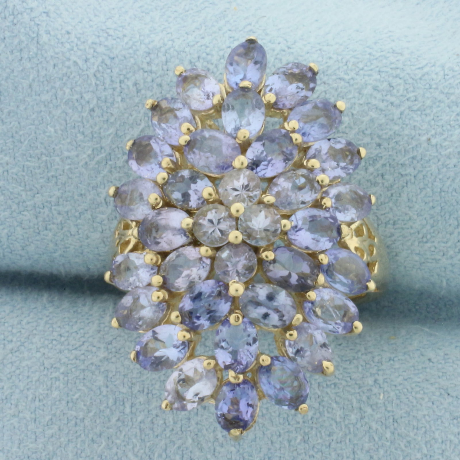 Tanzanite Statement Ring in 10K Yellow Gold: In 10k yellow gold. 1.125 inches wide at top of ring. Contains 34 high quality natural Tanzanite gemstones, 3ct TW, with bright color and excellent clarity. Size 7.25. 5.6g.