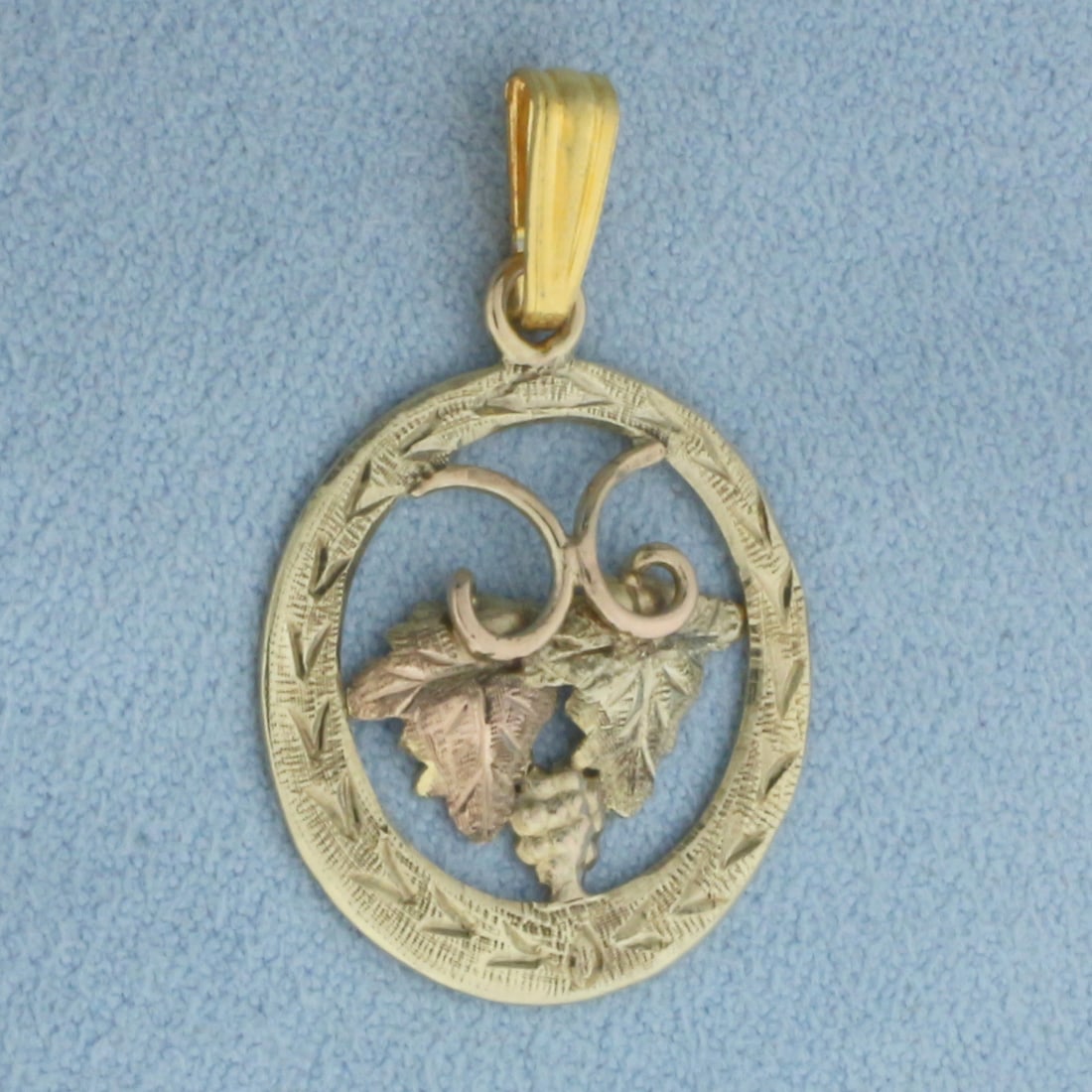 Black Hills Gold Grape Leaf and Cluster Pendant in 10k Yellow and Rose Gold: In 10k Yellow and Rose Gold. 1 1/8 inch long (including bale). 3/4 inch wide. Black Hills designer. 1.6g.