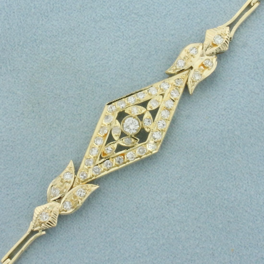 Diamond Bracelet in 14k Yellow Gold: In 14k yellow gold. 6.5 inches long by 5/8 inches wide at widest point. Contains one .2ct and forty .02ct high quality diamonds, 1ct TW, G color/VS clarity. Slide clasp with safety latch. 10.0g.