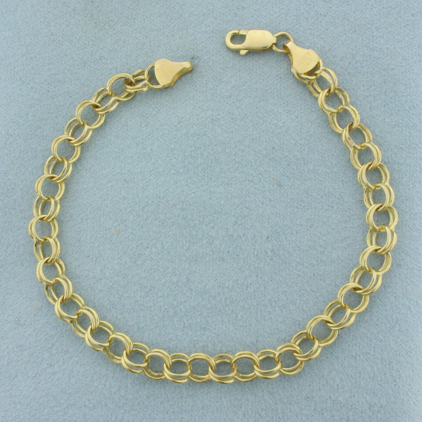 Double Loop Charm Bracelet in 14K Yellow Gold: In 14k yellow gold. 7 3/8 inches long by 5.6mm wide. Lobster clasp. 3.0g.