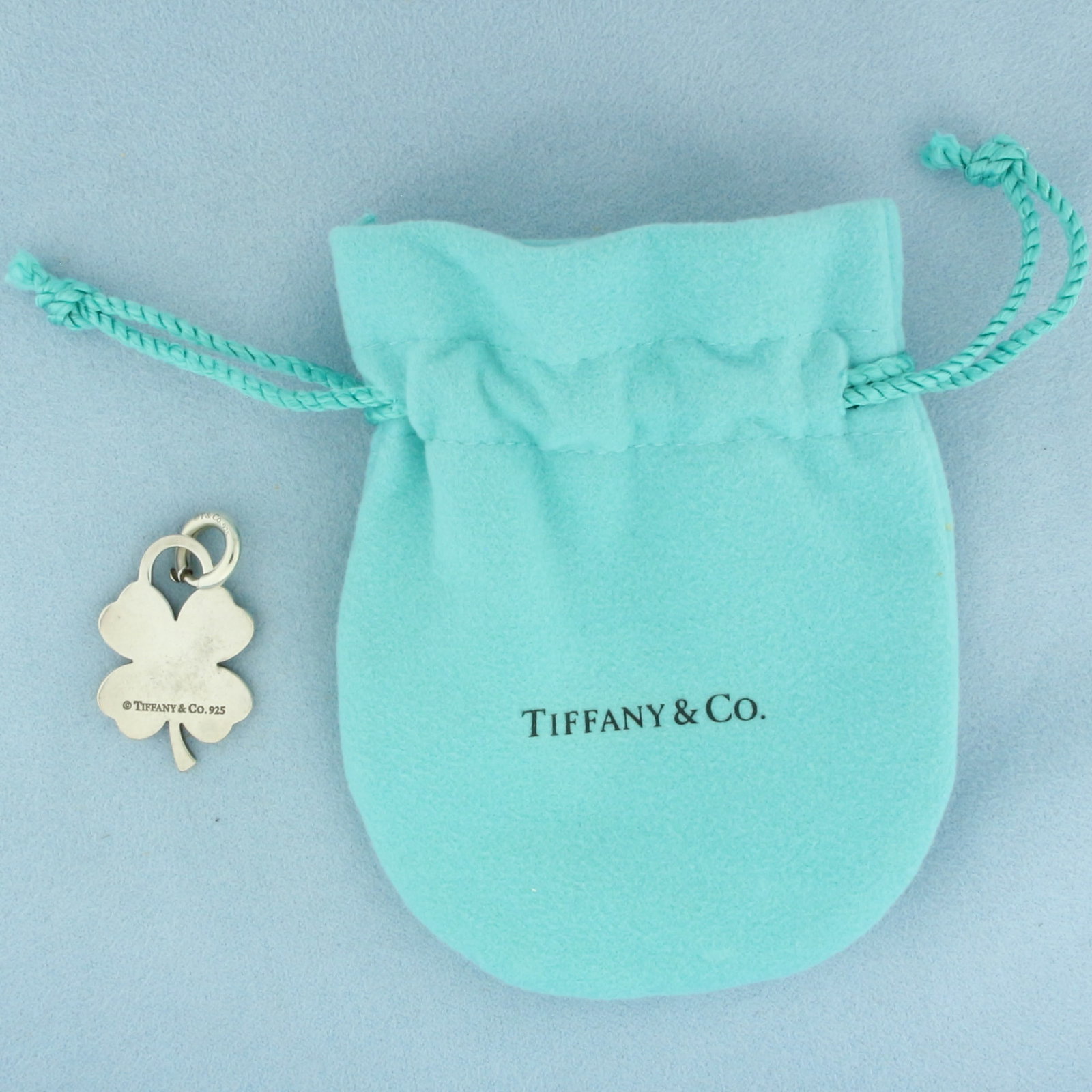 Tiffany and Co. Four Leaf Clover Shamrock Charm or Pendant in Sterling Silver: In .925 sterling silver. Charm is 1 1/8 inch high by 3/4 inch wide. Includes original pouch. Spring clasp for easy on/off.