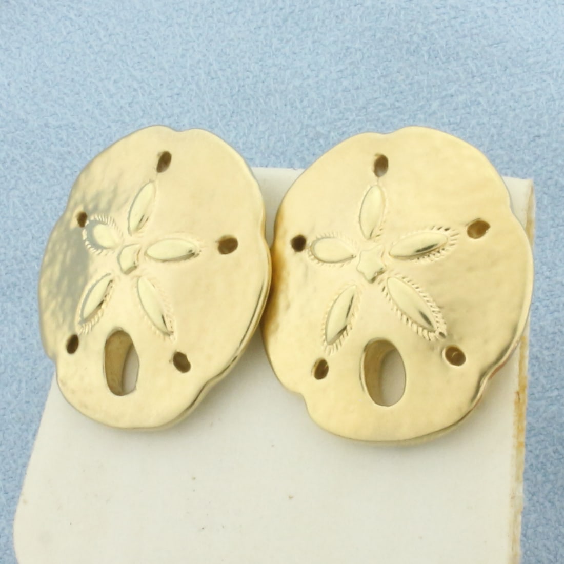 Large Sand Dollar Earrings in 14k Yellow Gold: In 14k yellow gold. Measures 1 inch long x 7/8 inch wide. Oversized friction backs for comfort and support. 7.0g.