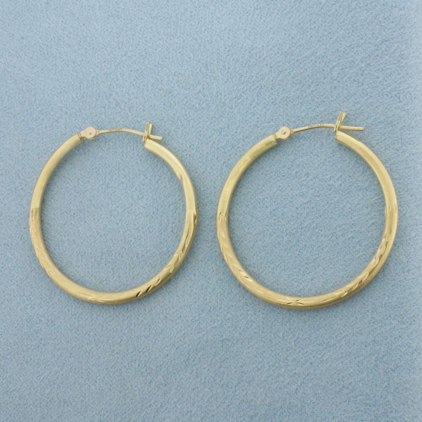 Diamond Cut Leaf Design Hoop Earrings in 14k Yellow Gold: In 14k Yellow Gold. 1 1/8 inch long. 1 1/8 inch diameter. 1.9mm wide tubes. Hinged closure. Very small dent on one earring, not noticeable. 1.3g.
