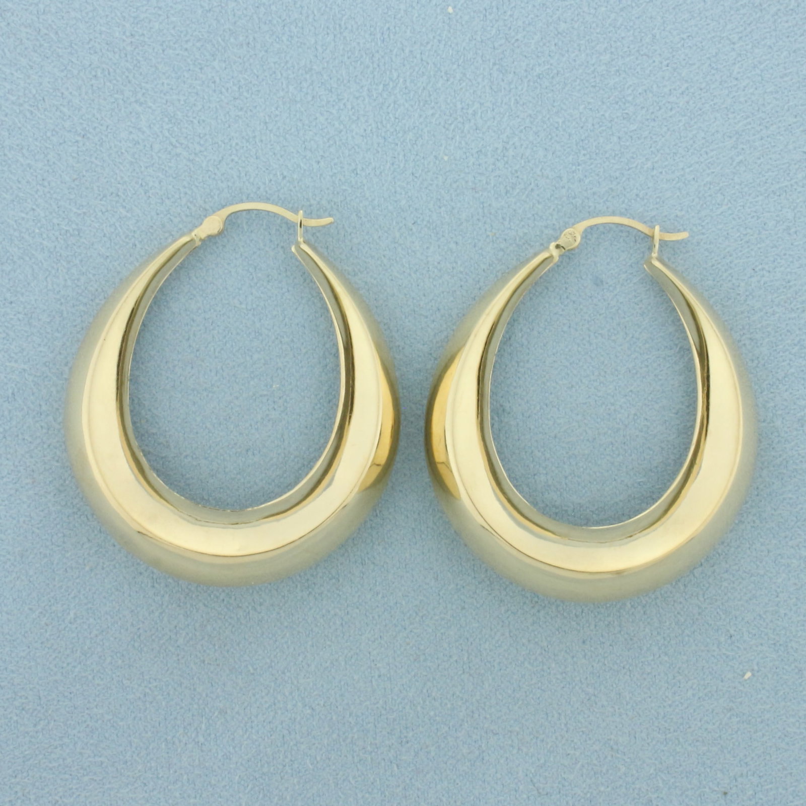 Puffy Crescent Hoop Earrings in 10k Yellow Gold: In 10k Yellow Gold. 1 1/2 inch long. 1 1/4 inch diameter. 7.7mm thick. Hinged closure. 4.6g.