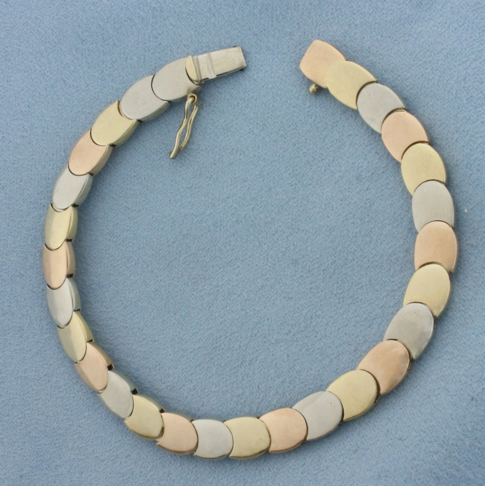 Tri-Color Oval Bracelet in 14k Yellow, White, and Rose Gold: In 14k Yellow, White, and Rose Gold. 7 1/4 inches long. 7mm wide. Concealed slide clasp with safety latch. 20.7g.