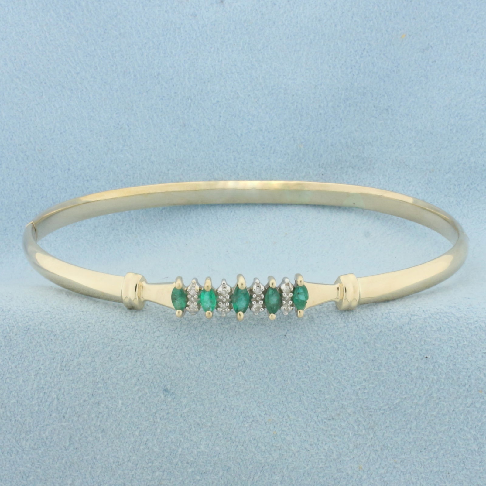 Hinged Emerald and Diamond Bangle Bracelet in 14K Yellow Gold: In 14k yellow gold. Inside diameter: 2 3/4 inches by 1 7/8 inches. Contains 4 marquise cut Emeralds, 4x2mm each, 1/2ct TW, with vibrant color. Accented with 8 high quality 1/2pt diamonds. Hinged locki