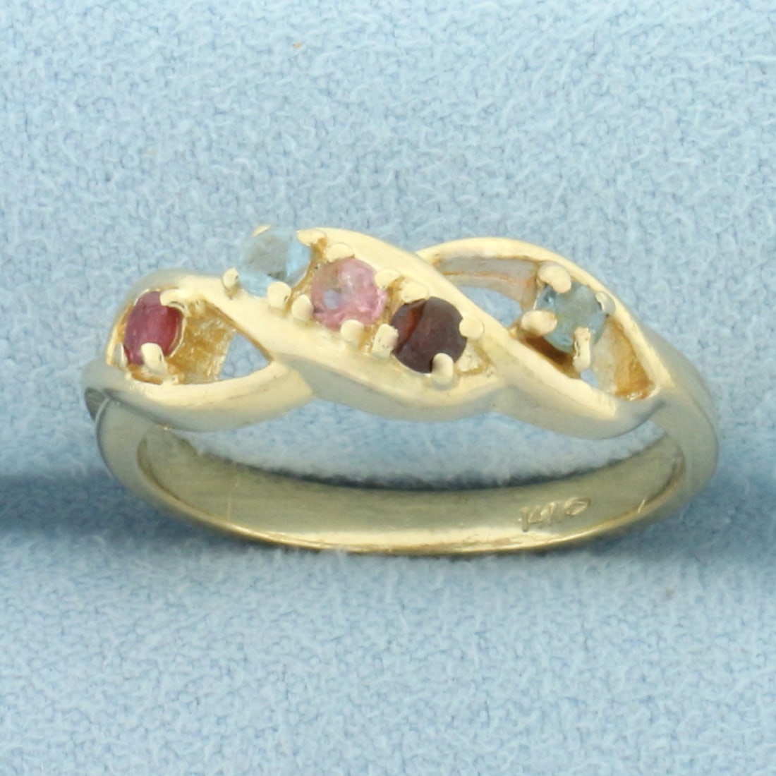 Vintage Rainbow Gemstone Twist Design Ring in 14k Yellow Gold: In 14k yellow gold. Contains five high quality natural 2.5mm gemstones including ruby, pink sapphire, blue topaz, and garnet. Some scratching and chips on gemstones, indicative of age. Size: 8.75. 4.4