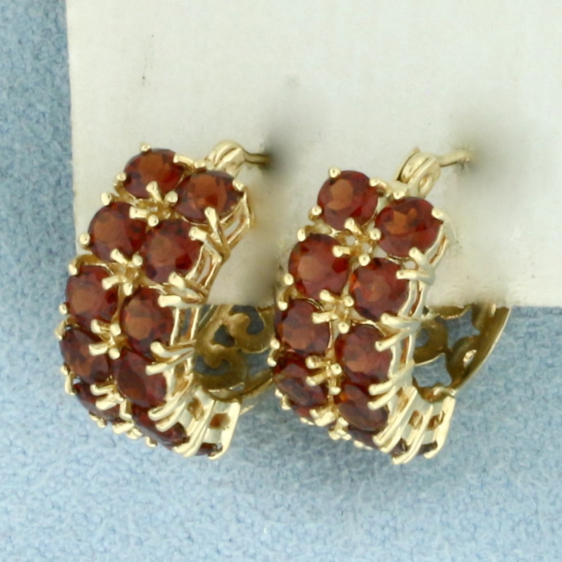 Garnet Huggie Hoop Earrings in 14k Yellow Gold: In 14k Yellow Gold. Contains twenty-four 3mm high quality natural Garnet gemstones, approximately 3ct TW, with deep color and excellent clarity. 5/8 inch long. 5/8 inch wide. 6.7mm wide from front vie