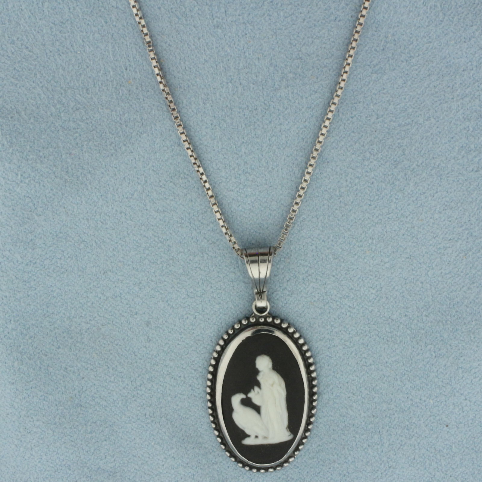 Wedgewood Jasperware Cameo Necklace in Sterling Silver: In .925 sterling silver. Chain is box link, 24 1/2 inches long, 1.1mm wide, with spring clasp. Pendant is 1 3/8 inches long (including bail) by 5/8 inches wide. Contains 1 Wedgewood cameo, Made in Eng