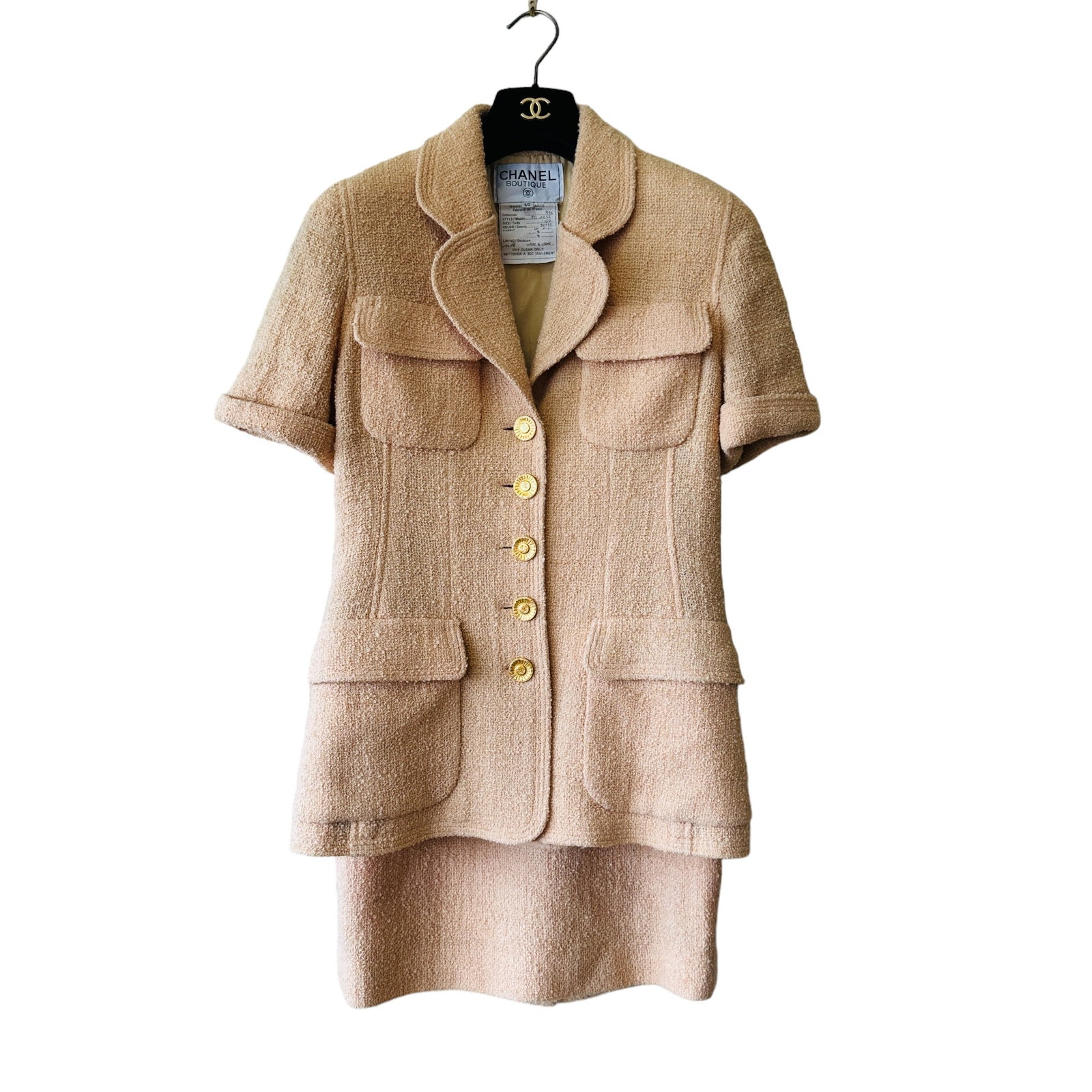Chanel Pastel Orange Gold Boucle Tweed Short Sleeve Sun Button Jacket & Skirt Suit Set 40: In size 40. From 93C. Set includes both short sleeve jacket and skirt. PO1252, 30935, VO2101. 100% wool, fully lined in 100% silk with iconic CC logo design and chain hardware on the bottom of jacket.