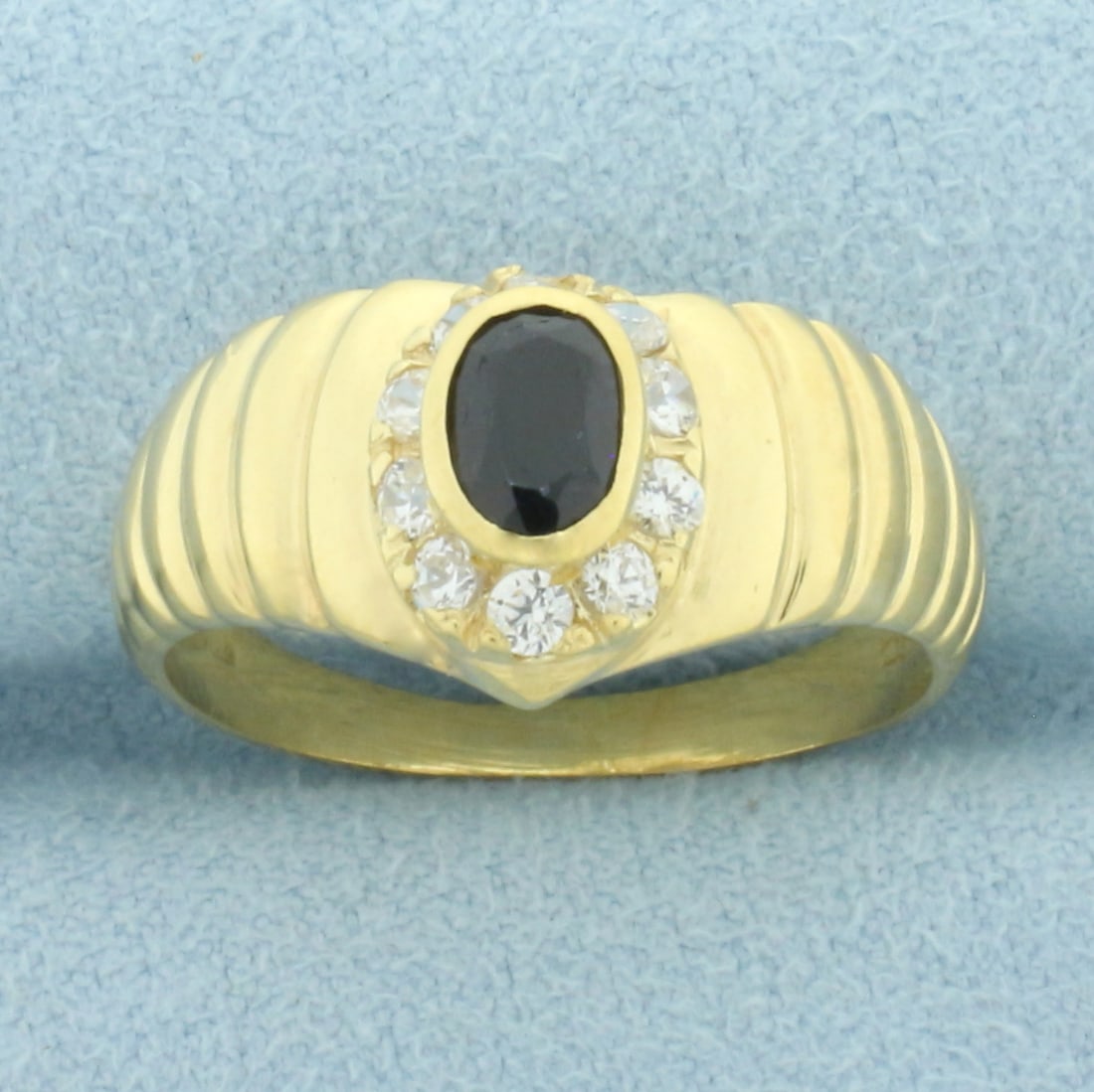 Sapphire and Diamond Halo Ring in 18k Yellow Gold: In 18k yellow gold. Contains one high quality natural 6mm by 4mm Sapphire gemstone with deep color and excellent clarity. Also contains ten high quality .03ct White Sapphire gemstones with excellent c