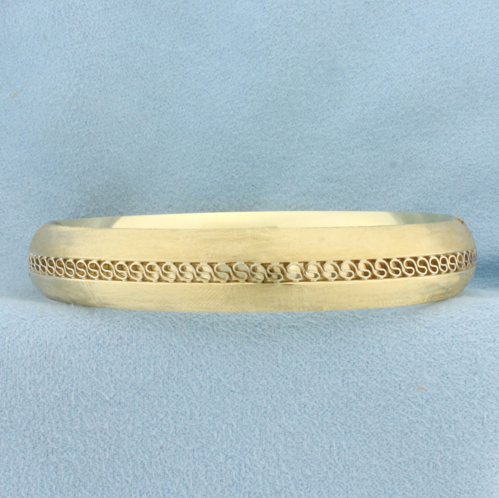 Brushed Finish Bangle Bracelet in 14k Yellow Gold: In 14k Yellow Gold. Interior dimensions: 2 3/8 inch by 2 1/8 inch. 11mm wide. Hinged closure. 18.4g.