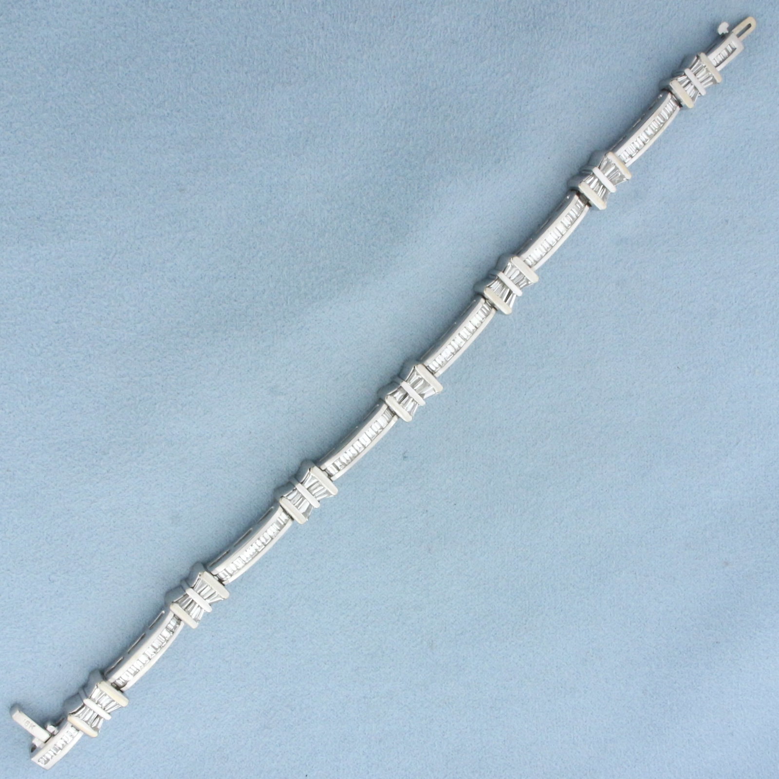 4ct Baguette Diamond Bracelet in 18k White Gold: In 18k White Gold. Contains 118 high quality baguette diamonds, 4ct TW, VS clarity/G color. 7 inches long. 1/4 inch wide. Concealed slide clasp with underswing safety latch. 30.0g.