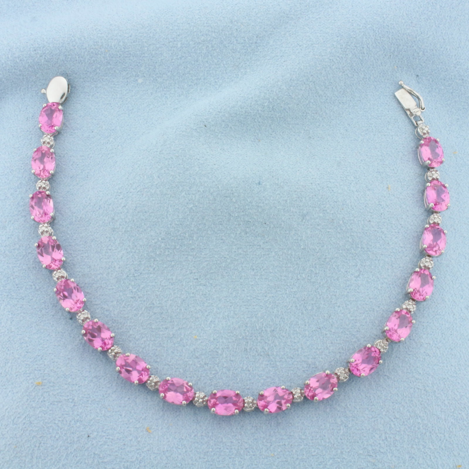 Pink Topaz and Diamond Tennis Bracelet in 10k White Gold: In 10k White Gold. Contains seventeen 5x7mm high quality natural Pink Topaz gemstones, approximately 17ct TW, with vibrant color and excellent clarity. Also contains seven high quality 1/2pt