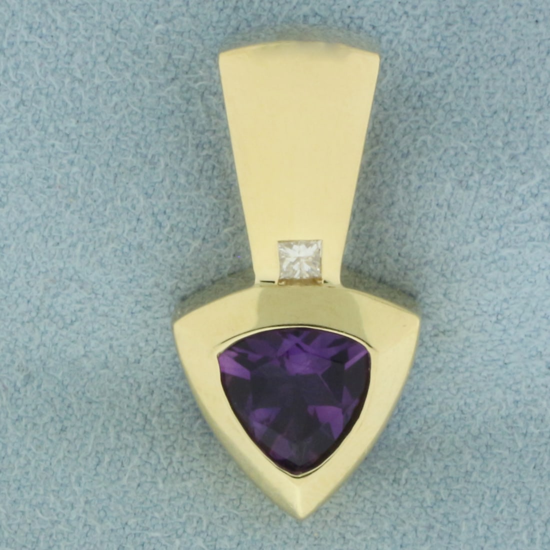 Amethyst and Diamond Pendant in 14K Yellow Gold: In 14k yellow gold. 1 inch long by 1/2 inch wide. Contains 1 high quality 8mm trillion cut Amethyst gemstone with vibrant color and excellent clarity. Also contains 1 high quality 2.5mm princess cut D