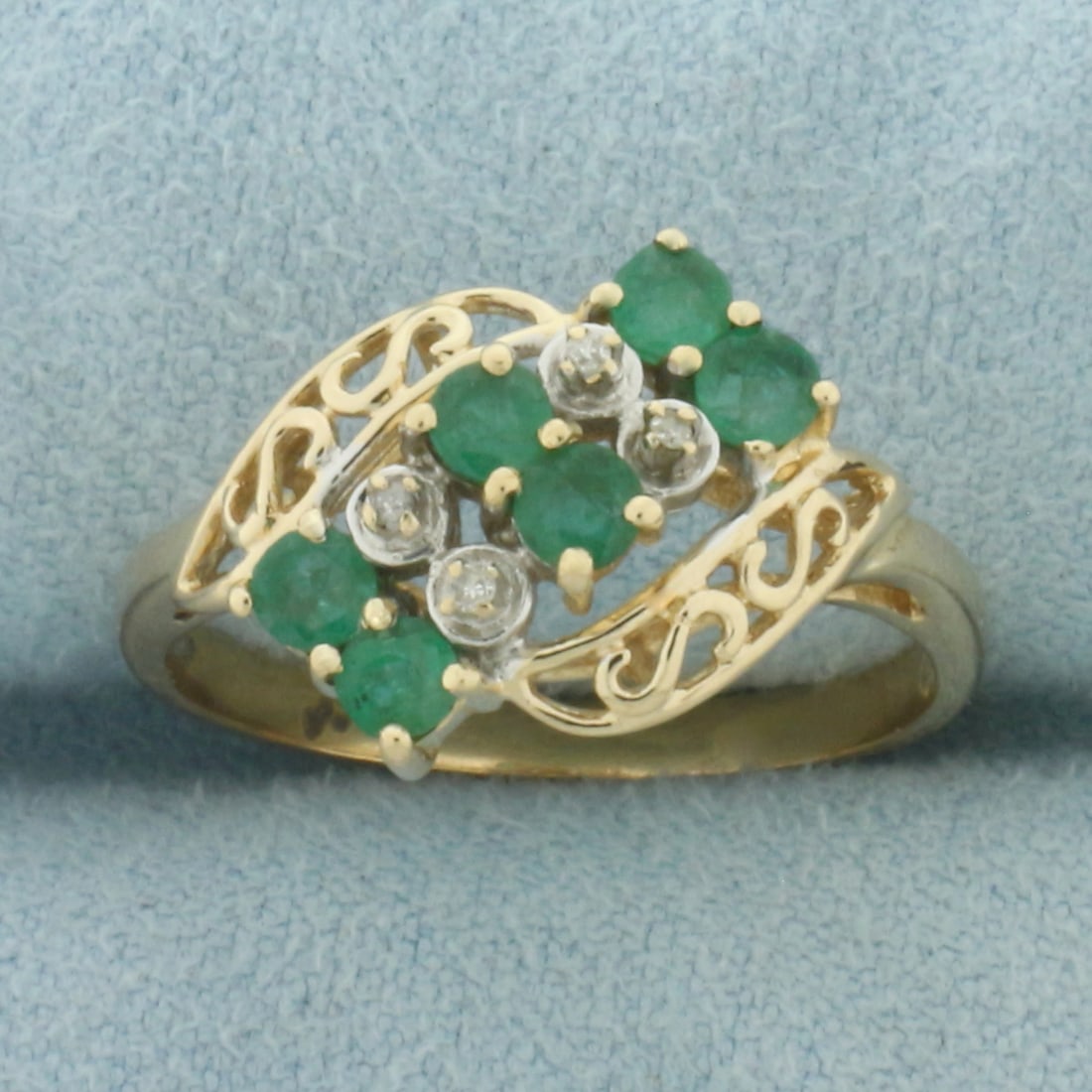 Emerald and Diamond Ring in 14K Yellow Gold: In 14k yellow gold. 13mm wide at top of ring. Contains six high quality natural 3mm Emerald gemstones with vibrant color. Accented with four high quality 1/2pt diamonds. Size 8.25. 3.1g.