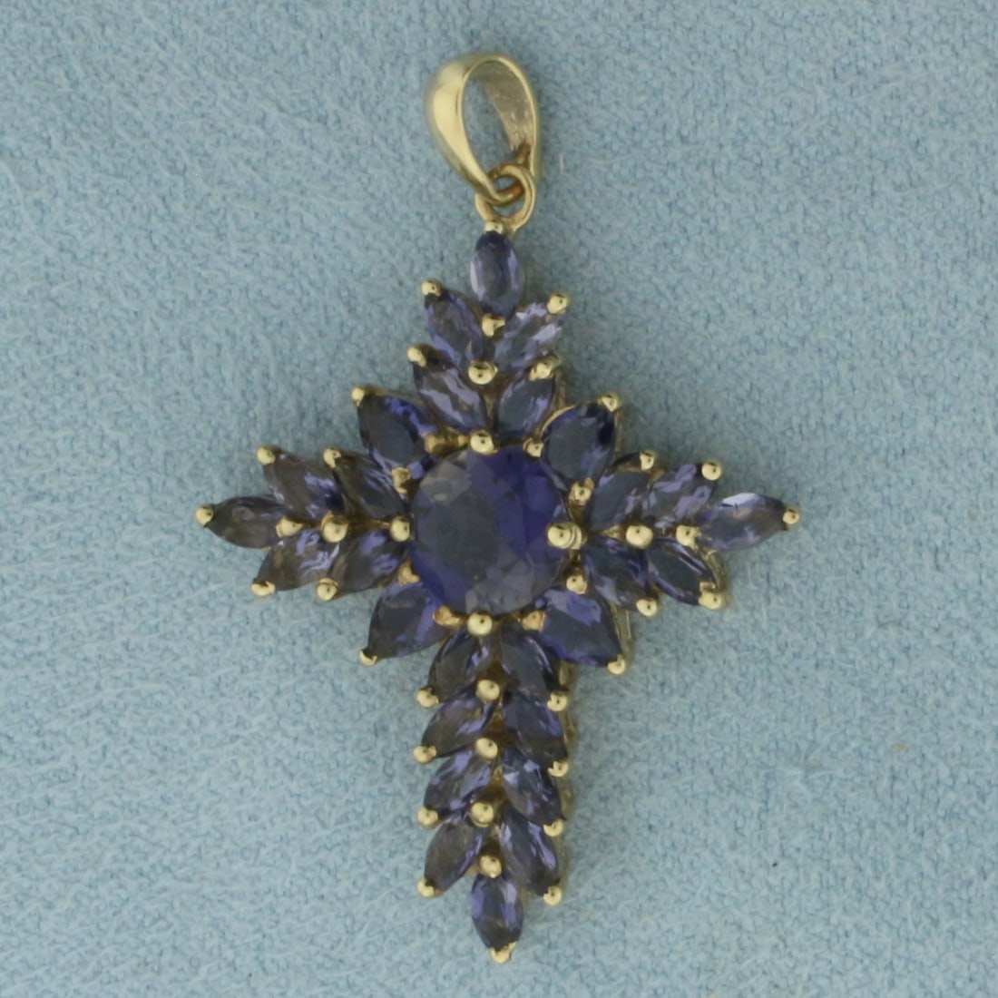 Tanzanite Cross Pendant in 10K Yellow Gold: In 10k yellow gold. 1 3/8 inch long (including bale) by 7/8 inch wide. Contains one 7mm round, four 4mm pear, and twenty four 4mm marquise high quality natural Tanzanite gemstones with intense color a