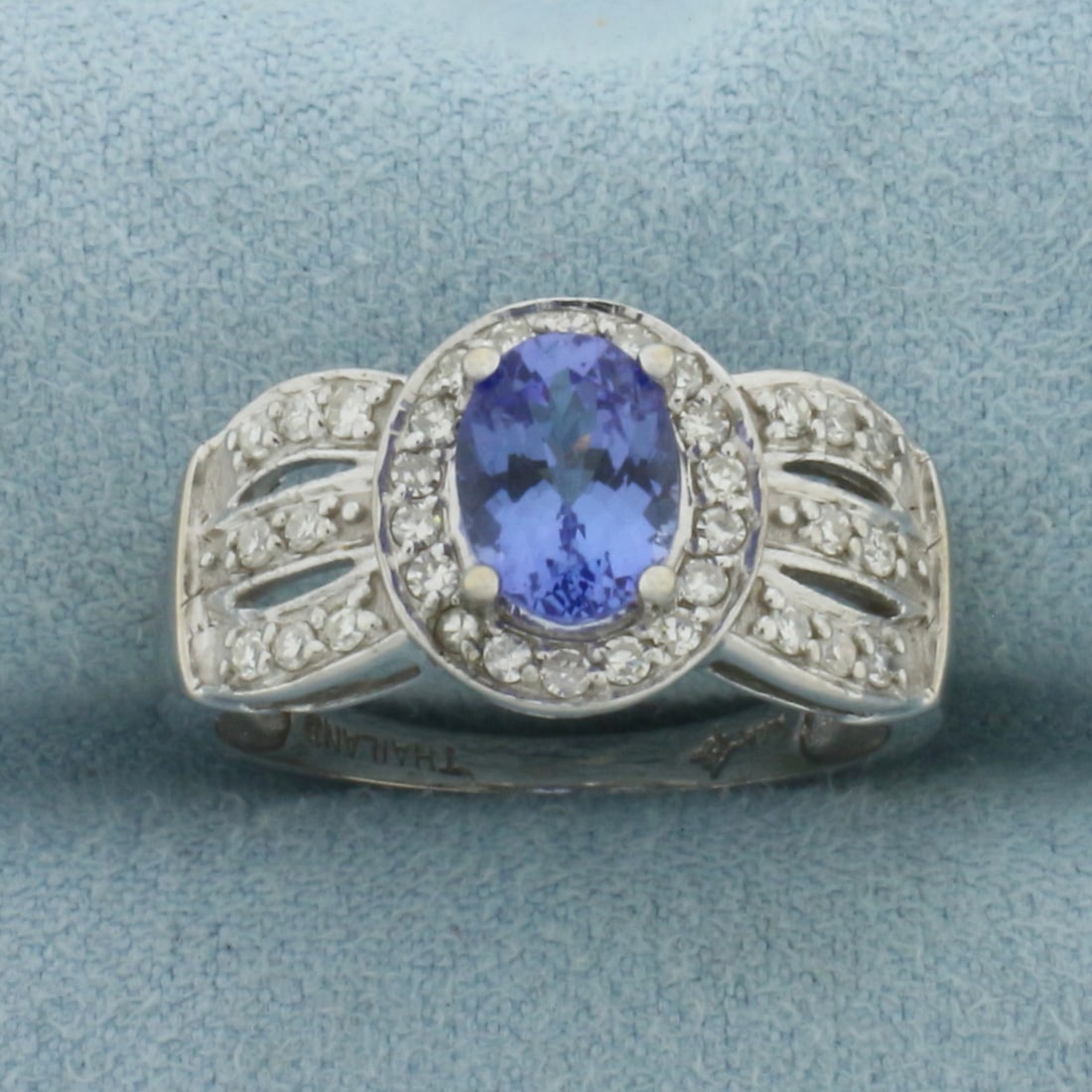 Tanzanite and Diamond Halo Ring in 14K White Gold: In 14k white gold. 11.5mm wide at top of ring. Contains 1 AAA quality 8x6mm Tanzanite gemstone, approximately 1.5ct, with intense color and excellent clarity. Accented with 34 high quality .01ct