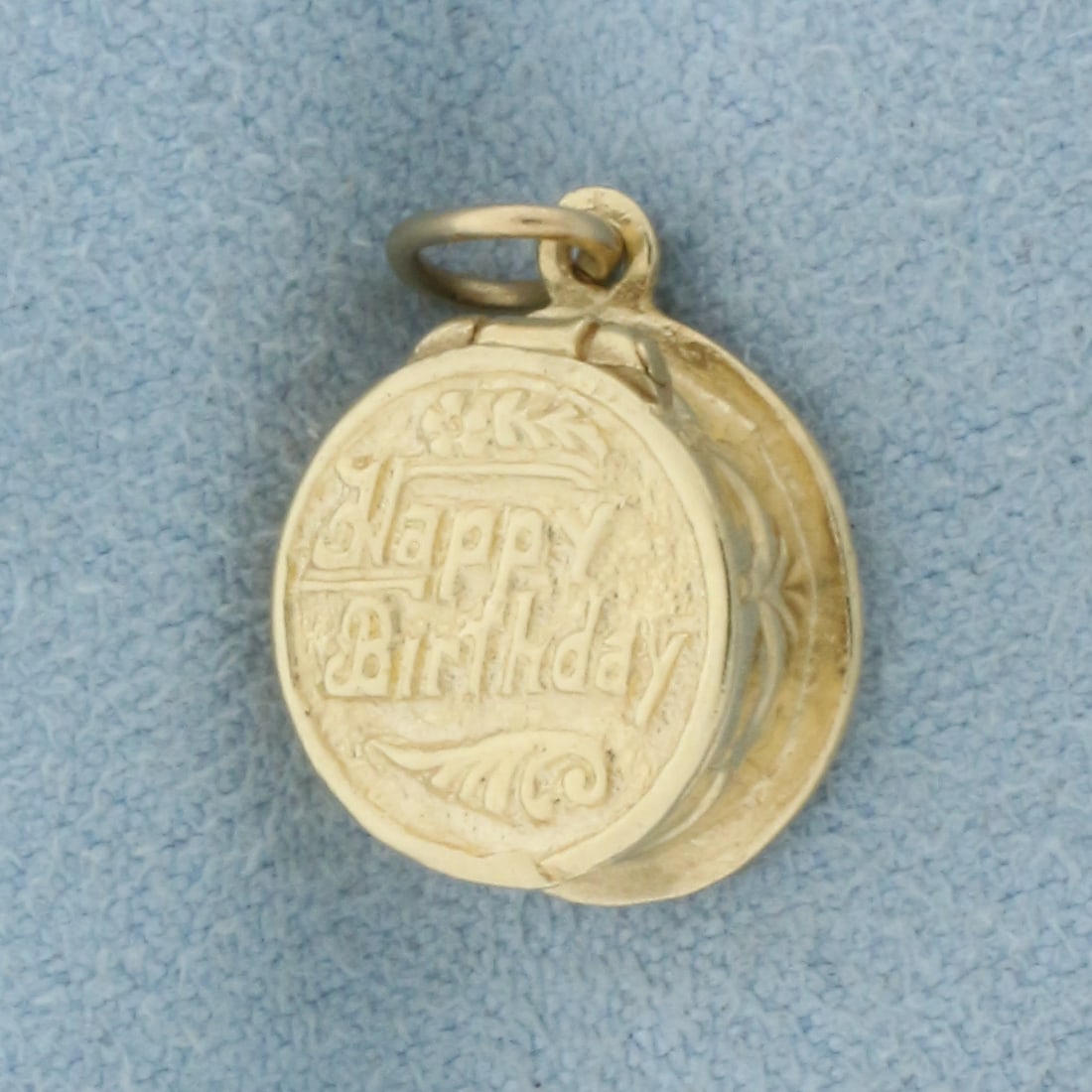 Opening Birthday Cake Charm in 14k Yellow Gold: In 14k Yellow Gold. 1/2 inch long. 1/2 inch wide. Cake opens, can put small object inside. 2.6g.