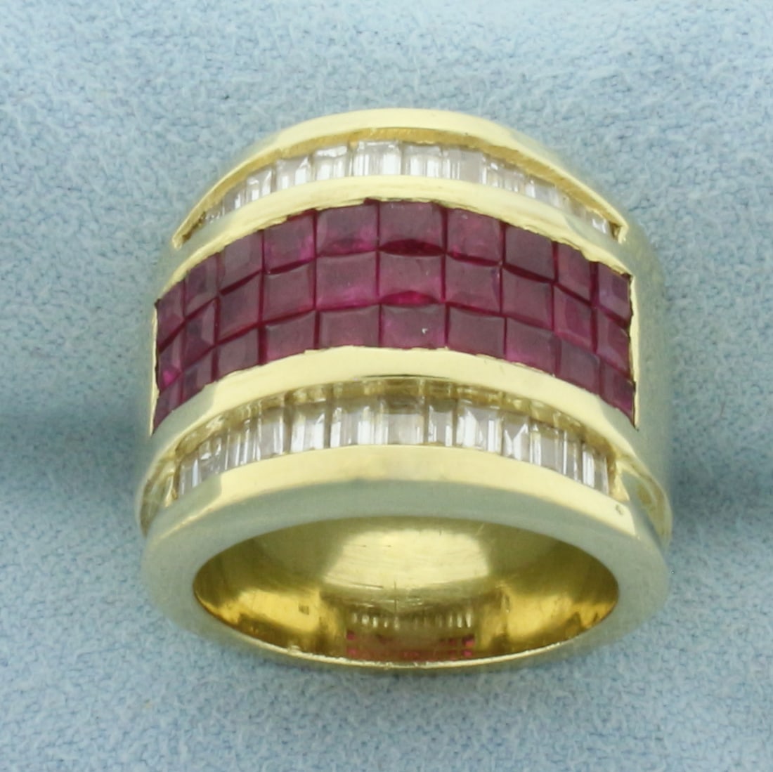 Invisible Set Ruby and Diamond Ring in 18k Yellow Gold: In 18k Yellow Gold. Contains thirty 2.5mm high quality natural princess cut Ruby gemstones, 2.5ct TW, with intense color and excellent clarity. Also contains twenty six 2.75mm high quality baguette di