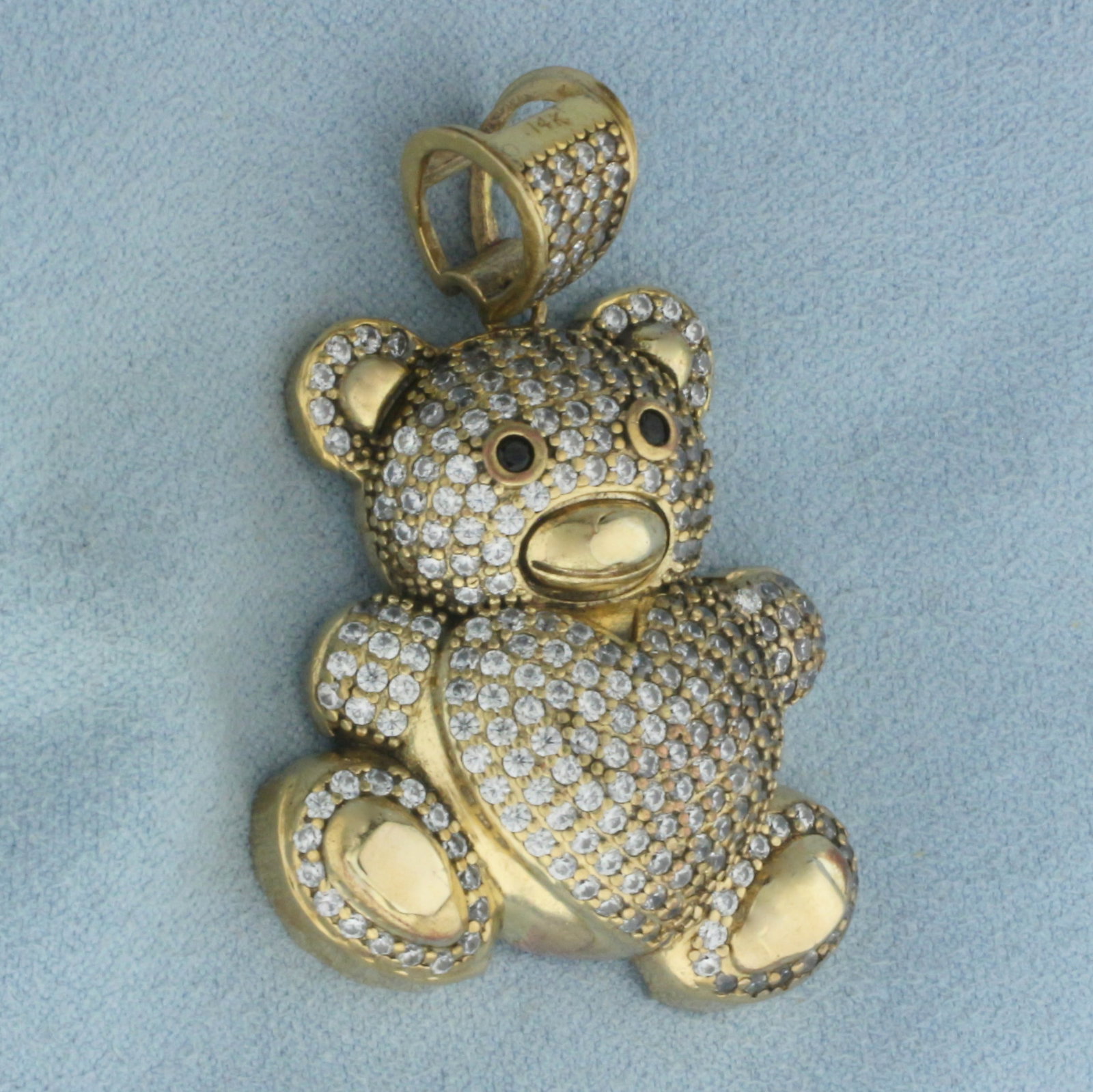 Large Teddy Bear Pendant in 14K Yellow Gold: In 14k yellow gold. 1 3/4 inches long by 1 1/4 inches wide. Contains two 2mm Sapphire gemstones and CZ gemstones throughout. 14.6g.