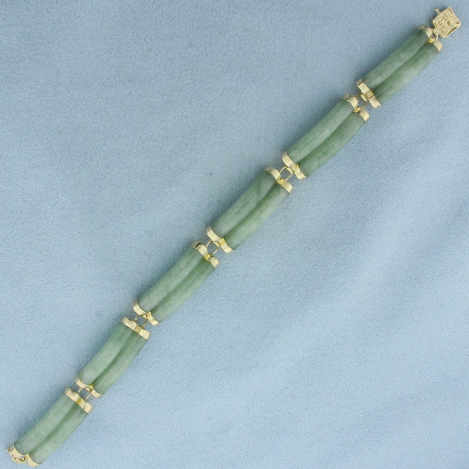 Jade Good Fortune Bracelet in 14K Yellow Gold: In 14k yellow gold. 7 inches long by 3/8 inch wide. Contains 12 high quality Jade Gemstones. Decorative slide clasp with safety latch. 19.8g.