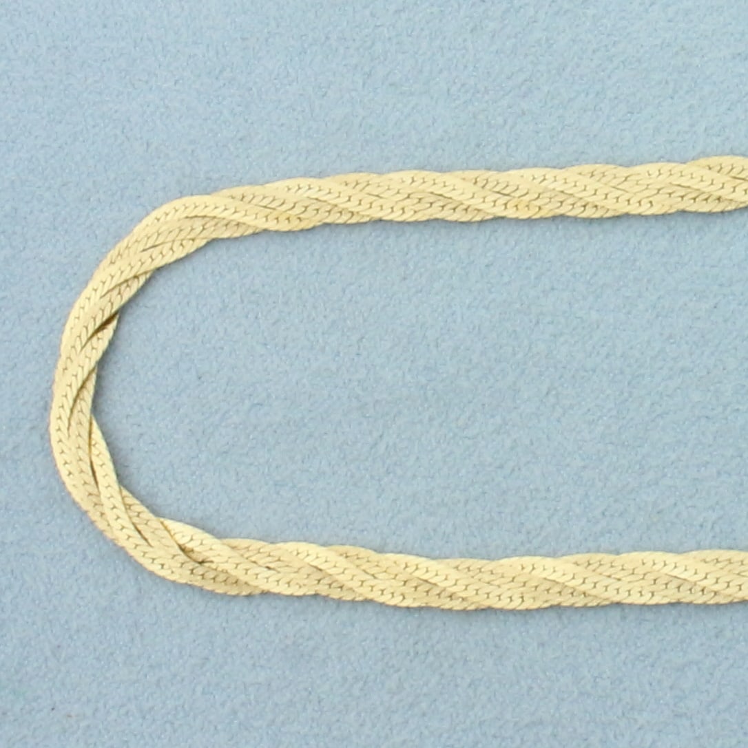 18 Inch Braided Herringbone Link Chain Necklace in 14k Yellow Gold: In 14k yellow gold. 18 inches long. 1/8 inch wide. Italian made. One strand is high polish, one strand is matte finish for unique look. Slide clasp with safety latch. 9.3g.