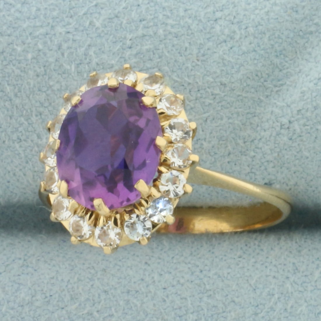 Lavendar and White Sapphire Halo Ring in 18k Yellow Gold: In 18k Yellow Gold. Contains one 10x8mm high quality natural Lavendar Sapphire gemstone, approximately 3cts, with vibrant color and excellent clarity. Also contains sixteen .03ct high quality white sa