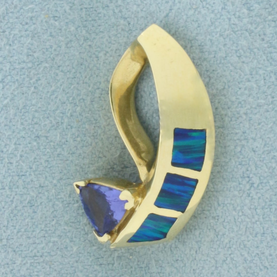 Tanzanite and Opal Inlay Pendant Slide in 14K Yellow Gold: In 14k yellow gold. 7/8 inch long by 1/2 inch wide. Contains 1 AAA quality trillion 6mm Tanzanite gemstone with vibrant color and excellent clarity. Also contains three 4mm inlaid Opal gemstones. 4.4g