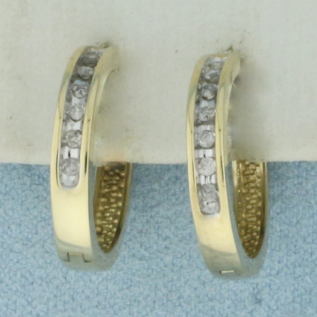 Diamond Hoop Earrings in 10K Yellow Gold: in 10k yellow gold. 5/8 inch diameter and 3mm wide. Contains 14 high quality natural .01ct diamonds. Hinged locking closures. 3.1g.