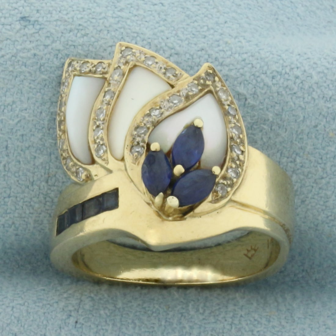 Sapphire Diamond and Mother of Pearl Ring in 14K Yellow Gold: in 14k yellow gold. 18.7mm wide at top of ring. Contains three 5x2.5mm marquise and four 2mm square step cut high quality natural Sapphire gemstones with intense color and excellent clarity. Accented 