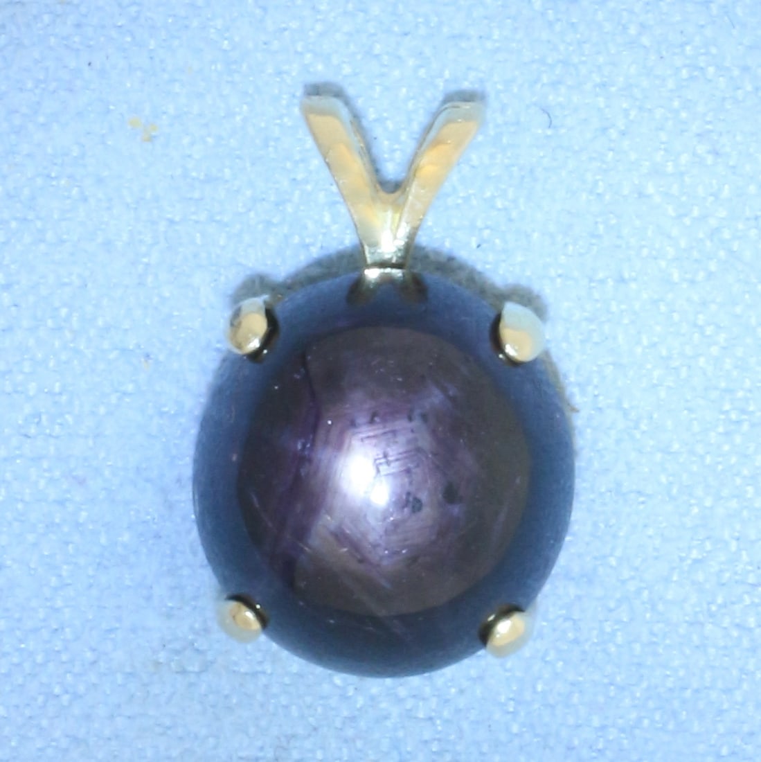Star Sapphire Pendant in 14K Yellow Gold: In 14k yellow gold. 5/8 inch long by 3/8 inch wide. Contains 1 high quality natural 12x11mm Star Sapphire gemstone with distinct star under light. 2.7g.