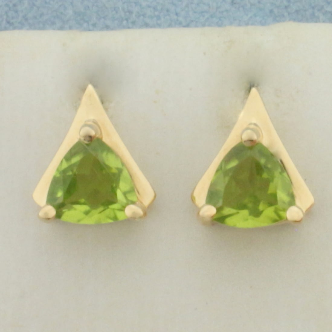 Peridot Trillion Stud Earrings in 14K Yellow Gold: In 14k yellow gold. Contains 2 high quality natural Peridot gemstones, 2ct TW, with bright color and excellent clarity . 3/8' long by 1/4" wide with friction backs. 2.0g.
