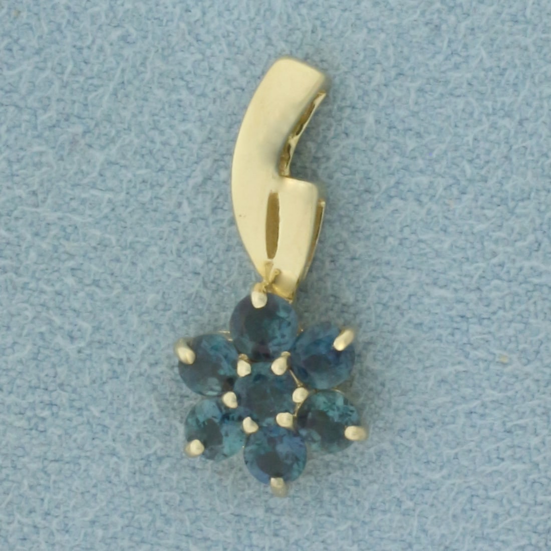 Alexandrite Flower Pendant in 14K Yellow Gold: In 14k yellow gold 3/4 inch long by 3/8 inch wide. Contains 7 high quality natural Indian Alexandrite gemstones, 1.5mm each, 0.179ct TW. Changes color from green to red under different light as shown.