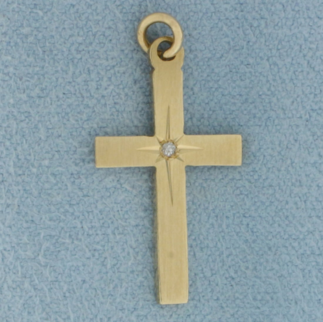 Diamond Cross Charm in 14K Yellow Gold: In 14k yellow gold. 1 inch long (including jump ring) by 1/2 inch wide. Contains one high quality 1/2pt diamond. 1.0g.