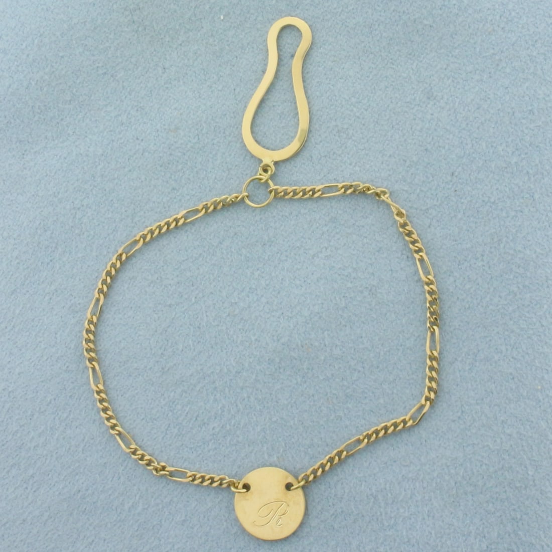 Men's R Monogram Tie Charm in 18K Yellow Gold: In 18k yellow gold. 2mm wide Figaro link chain with button attachment and 10mm wide center disc. 2.9g.