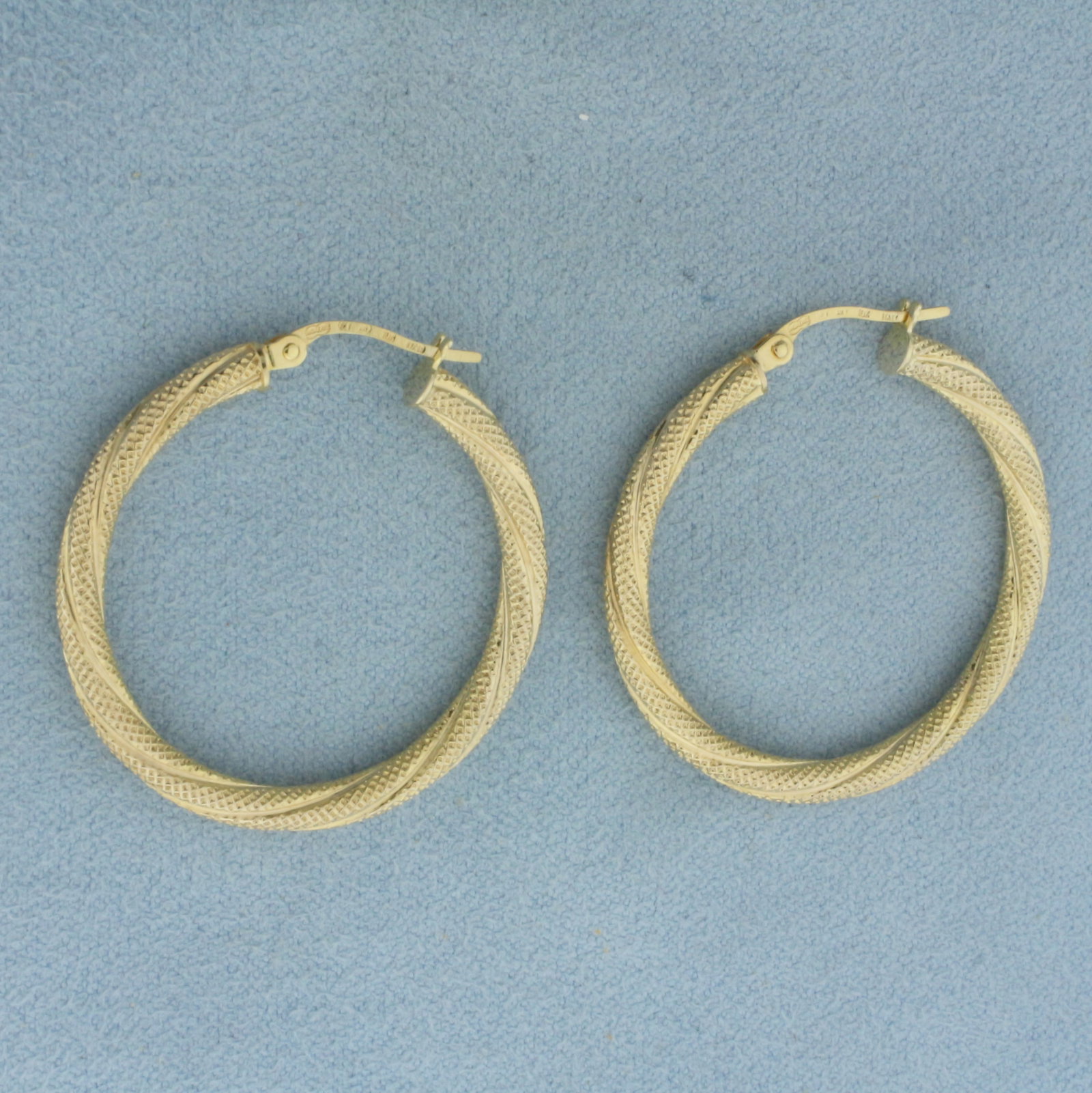 Italian Twisting Textured Hoop Earrings in 10K Yellow Gold: In 10k yellow gold. Italian made. 1 1/8 inches in diameter and 3mm tubes with leverbacks. Textured for unique look. 1.6g.