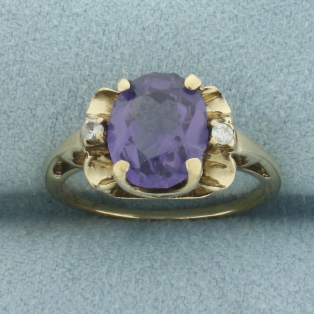 Color Changing Sapphire and Diamond Ring in 14k Yellow Gold: In 14k yellow gold. 10mm wide at top of ring. Contains 1 high quality 10x8mm Color Changing Sapphire, approximately 3ct, with distinct change from purple to pink under different light. Gemstone does h