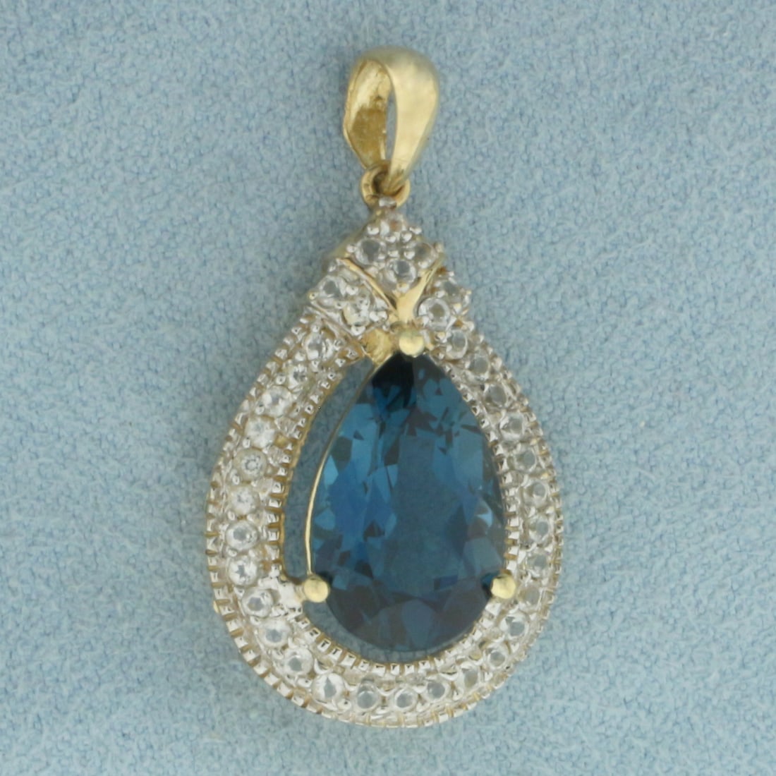 London Blue Topaz and Diamond Pendant in 10K Yellow Gold: In 10k yellow gold. 1 1/4 inch long (including bail) by 5/8 inch wide. 1 high quality natural pear London Blue Topaz gemstone, 14x9mm, approximately 8.5cts, with deep blue color and excellent clarity.