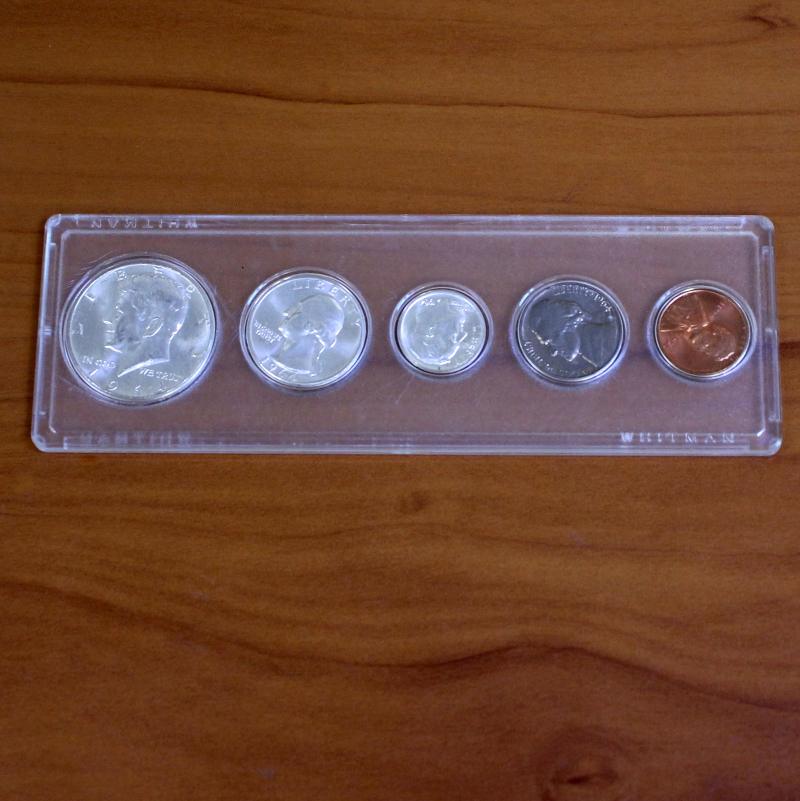 Uncirculated Silver Kenney Half Dollar Coin Set in Slab: One coin set from 1964. Includes one silver Kennedy half dollar, one silver quarter, one silver dime, one nickel, and one penny. Set in slab.