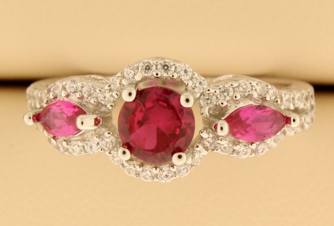 Sterling Silver ring with Rubies: Lovely sterling silver ring with beautiful round lab Ruby center and accented with two marquise cut lab Rubies, one on either side, all set in a stunning and extremely fashionable Halo design decorate