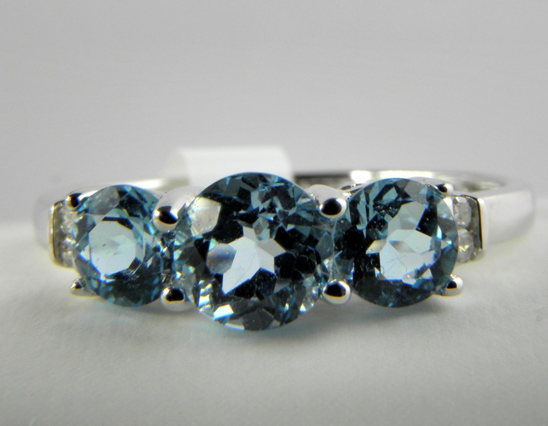 Classic 3-Stone Blue Topaz with Diamonds Ring in 14K: 14k White Gold mounting with 3 Swiss Blue Topaz, 1.00ctw, and 4 diamonds, .02ctw. Ring weighs 1.8 grams total weight. Electronically tested gold, gemstones and diamonds. Bid with confidence.