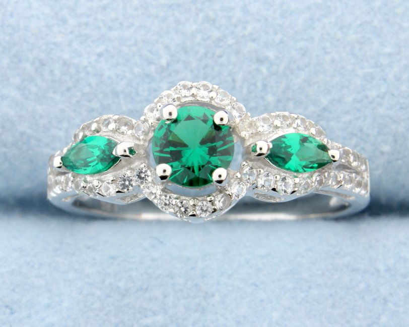 Lab emerald and white sapphire ring: Lovely sterling silver ring with beautiful round lab Emerald center stone and accented with two marquise cut lab Emeralds, one on either side, all set in a stunning and extremely fashionable Halo desi