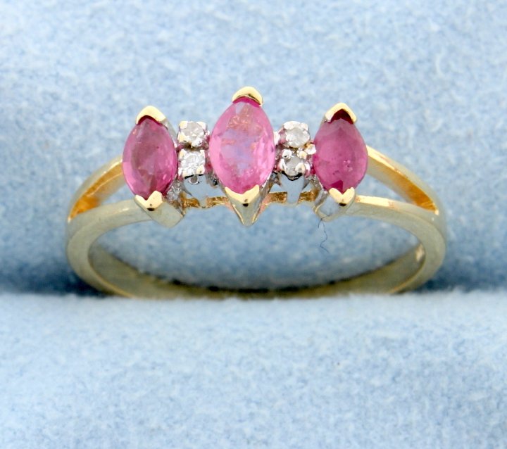 Ruby & diamond ring: Beautiful 10k yellow gold ring with 4 diamonds that weight 0.05 carats total and 3 marquise cut Ruby's that weigh approx. 1/2 carat. Size 6 1.8g